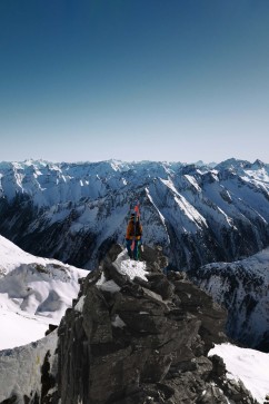 Roman Rohrmoser steht mit Ski am Gipfel des Berges