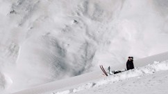 Kameramann wartet im Schnee um einen Skifahrer zu filmen