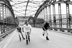 Inline Skater fahren gemeinsam über eine Brücke