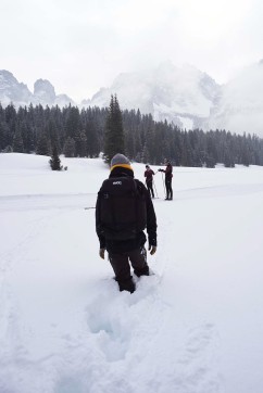 Kameramann läuft durch den Schnee zu Langläufern